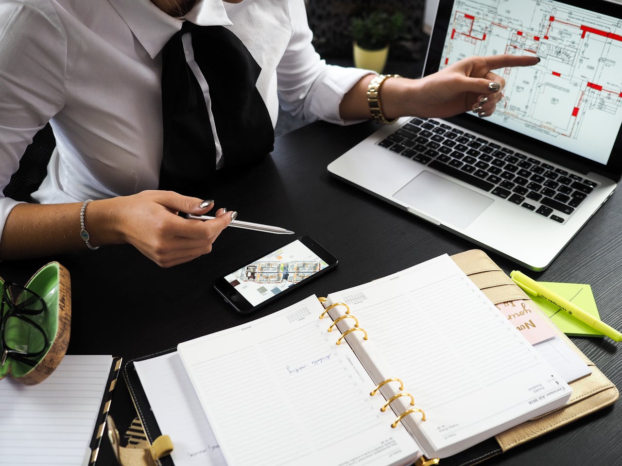 creative A business professional working on real estate project plans using multiple devices in an office setting.